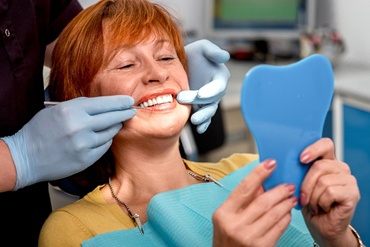 dentist showing a patient their smile in a mirror