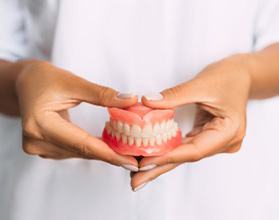 Lady presents viewer with dentures