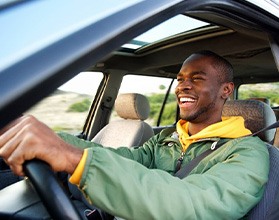 Man smiles while driving