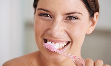 Happy woman brushing teeth