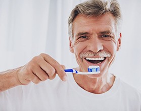 man brushing his dental implants in Chevy Chase