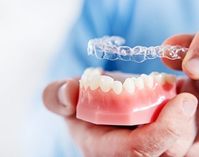 A dentist placing an Invisalign aligner over the top of the lower arch in Chevy Chase