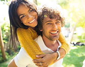 A young couple showing off their straighter smiles thanks to Invisalign in Chevy Chase