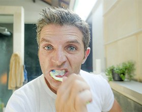 Man brushes teeth