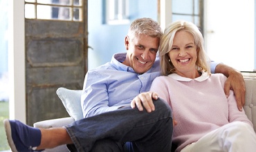 elderly couple sitting on a couch together 