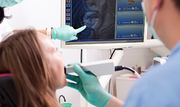 Patient and dentist examine images of smile