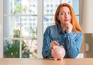 Woman putting coin in piggy bank