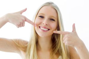 Woman pointing to her smile