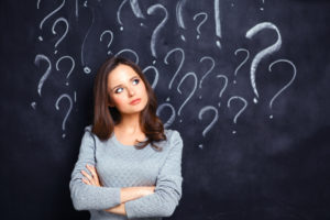 woman in front of chalkboard with question marks