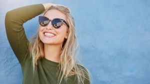 woman in sunglasses smiling with veneers in Chevy Chase 