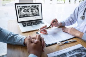 dentist showing jaw and teeth with X-ray during consultation 