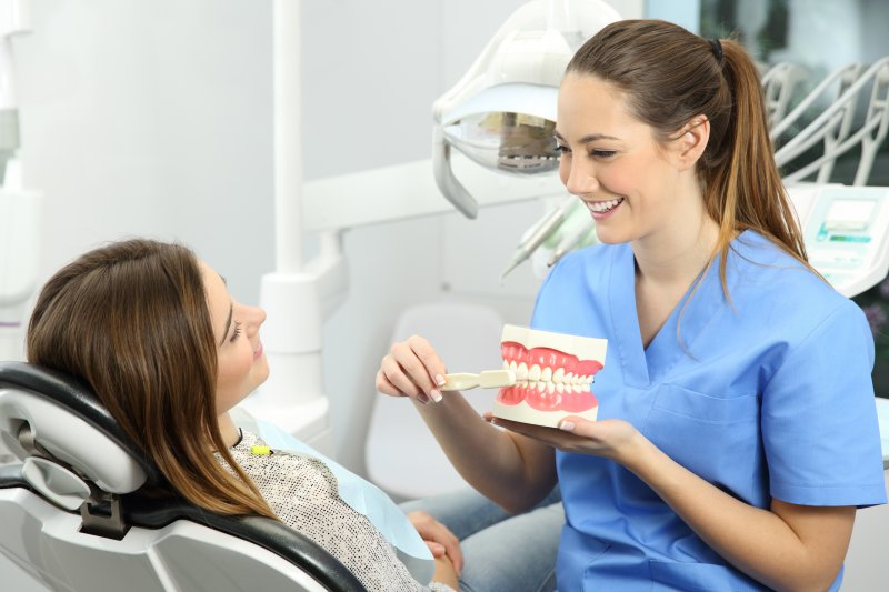 A dentist and patient with good patient habits smiling together