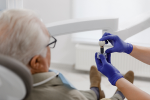 a patient and dentist examining a dental implant model
