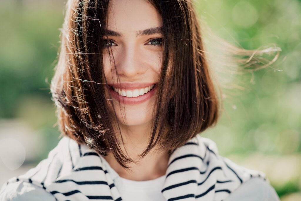 Woman with brown hair outside smiling